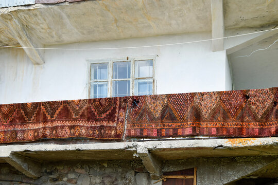 Antique rug hang over weathered apartment balcony