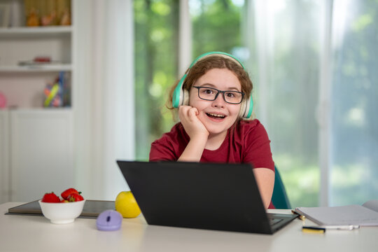 Study child works at desk. Study student uses notebook online. Focused learner continues study indoors. Young kid enjoys study lesson.