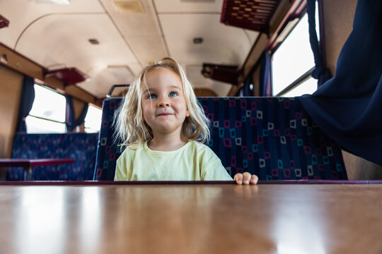 Young girl sitting inside a passenger train carriage