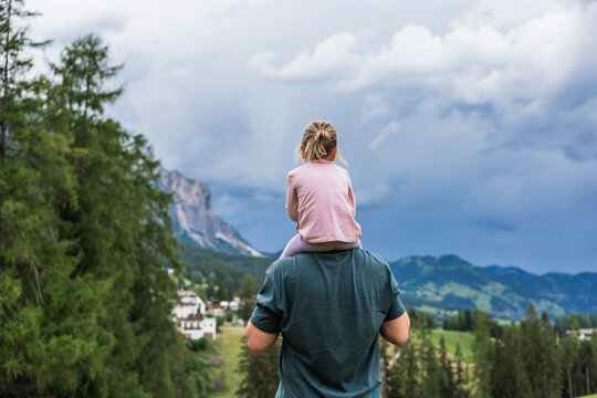 Father carrying daughter in the Dolomites near La Villa