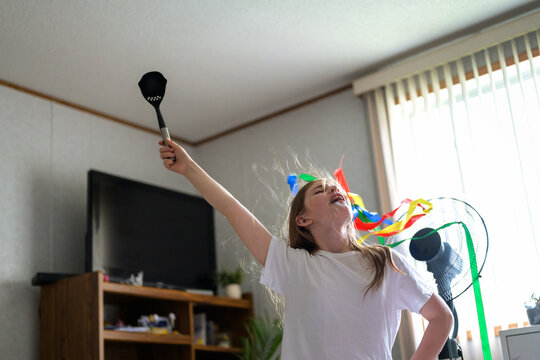 Joyful child pretending to be pop star at home