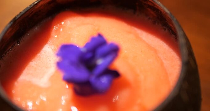 Close up of cold strawberry smoothie garnished with blue butterfly pea flower