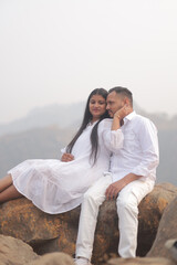 Fototapeta premium Romantic Indian couple sharing an intimate moment while embracing in a beautifully decorated traditional interior with patterned textiles.