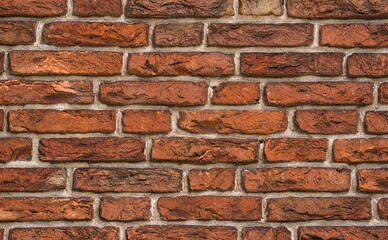 Fototapeta premium Brick wall with aged reclaimed material. Brick pattern on a rustic exterior. Antique weathered brick in close detail. Architectural texture of brick and mortar.