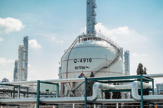 Petroleum Refinery Oil and Gas plant industrial complex building. Petrochemical industry site outdoor exterior with storage tank and pipes.