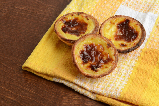  closeup Portuguese Custard Tarts Pasteis de Nata on a checkered napkin