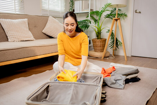 Woman Packing Clothes into Suitcase Before Vacation