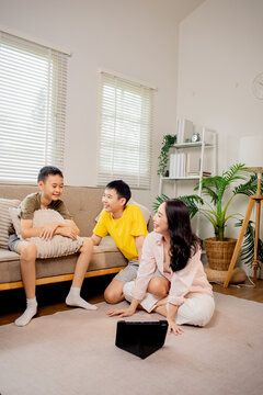 Mother and children using tablet together at home