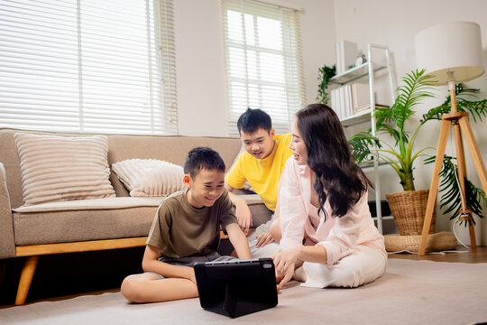 Mother and children using tablet together at home