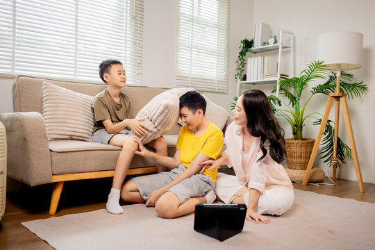 Mother and children using tablet together at home