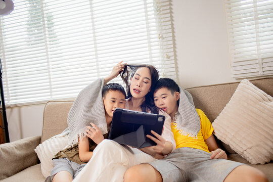 Mother and children using tablet together at home