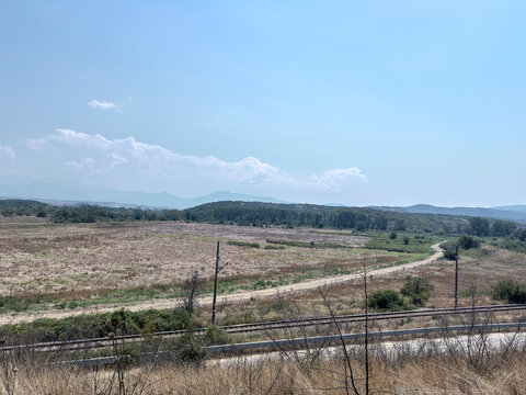 Dry rural countryside landscape with distant blue mountains