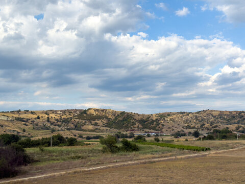 Rural valley with rolling hills beneath cloudy sky