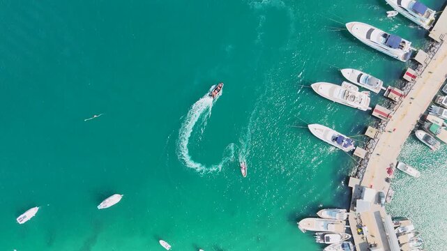 Aerial Drone Orbit Over Turquoise Marina with Speedboat Wake
