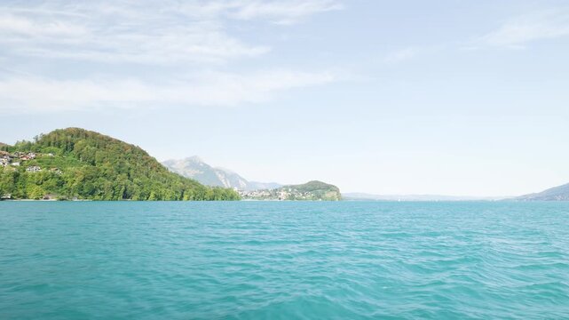Beautiful scenic view of lake lucerne and the swiss alps from a moving boat on a sunny day. Switzerland