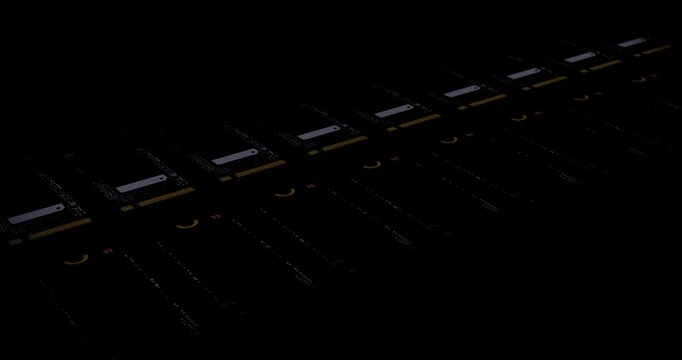 Rows of computer solid state drives moving on factory conveyor belt under blinking scanning light in dark space illustrating semiconductor production