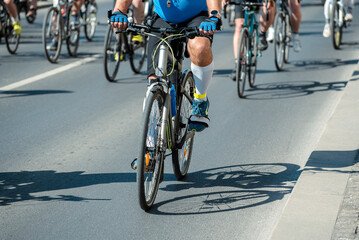 Fototapeta premium Cyclist Riding Bicycle in Urban Race with Group of Bicyclists on City Street