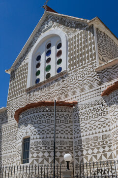 Traditional Byzantine church facade featuring iconic black and white scratched engravings in the mastic village of Pyrgi