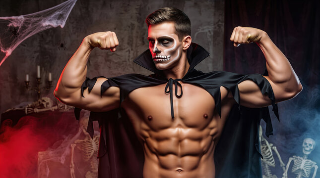 Shirtless muscular Caucasian man wearing skeleton face paint and vampire cape flexing muscles. Concept of Halloween costume, spooky bodybuilding fitness, and holiday party.