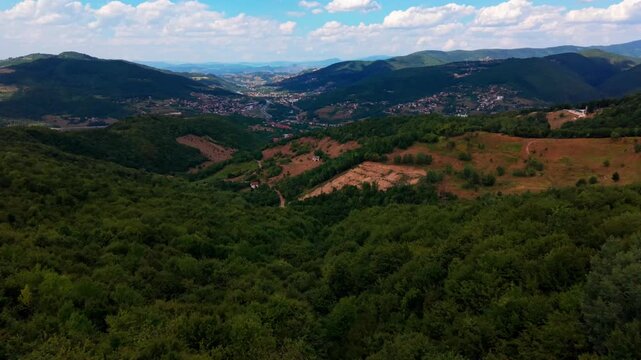 Aerial Landscape View of Green Forested Hills and Valley Overlooking Sarajevo City in Distance Sky Clouds