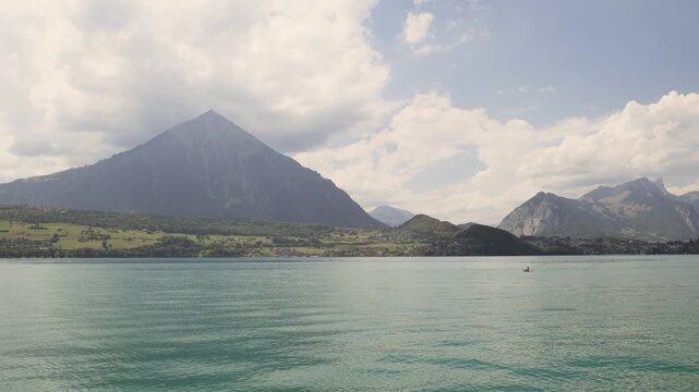 Beautiful alpine landscape featuring the turquoise waters of lake thun and the swiss alps. Switzerland