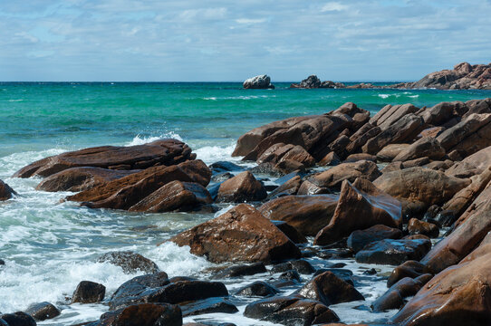 Rocky coastline with turquoise ocean and granite boulders