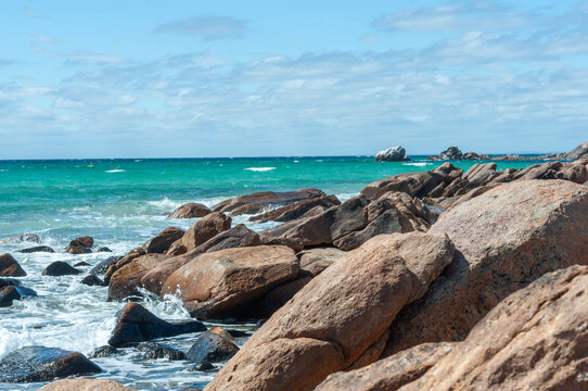 Granite boulders beside clear aquamarine seawater