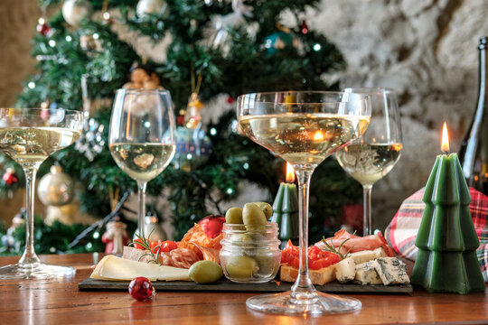 Christmas Holiday Celebration With Champagne Glasses And Charcuterie Board By A Decorated Tree