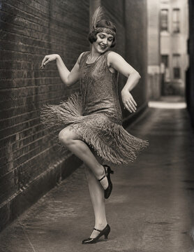 Joyful 1920s flapper dancing in fringed dress