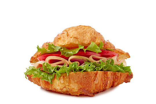 Crispy golden croissant sandwich filled with ham lettuce tomato and onion closeup frontal studio shot, with croissant, sandwich, ham, lettuce detail, showing tomato, onion, crispy, golden context