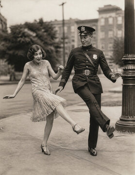 Flapper dancing with amused 1920s policeman