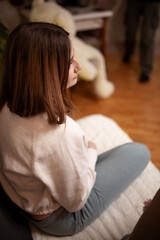 Fototapeta premium Woman Sitting in a Cozy Living Room Setting With a Warm Atmosphere