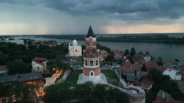 Forward drone approach toward Gardos Tower in Zemun, Belgrade, under dramatic stormy twilight sky with lightning.