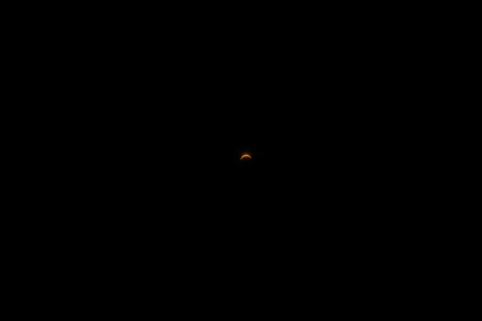 Partial solar eclipse showing the moon passing in front of the sun