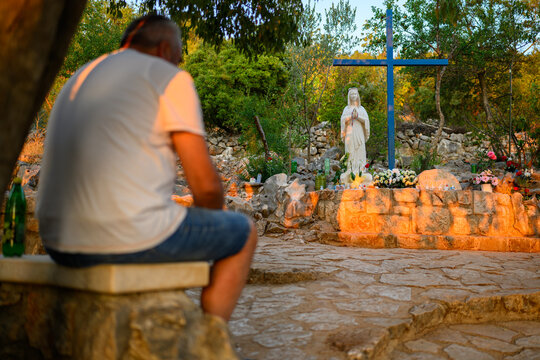 A man praying at the Blue Cross, one of the sites associated with the apparitions, at the foot of Mount Podbrdo in Medjugorje.