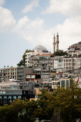Naklejka premium Panoramic view of dense residential buildings and mosque minarets built on a hill in Istanbul. Classic Turkish urban landscape representing travel destination and oriental architecture concept.