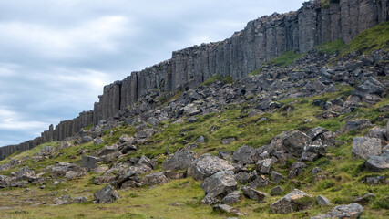 Gerduberg basalt column cliff rising above a rocky grass covered landscape on the Snaefellsnes Peninsula in Iceland. © Asanee