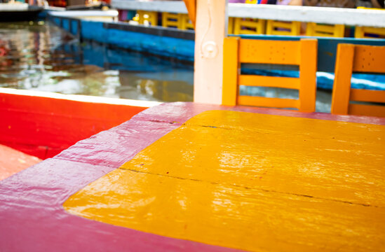 Colorful pink and yellow wooden table aboard a trajinera boat in Xochimilco