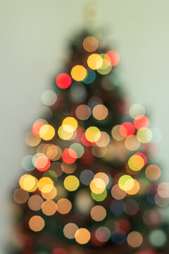 Christmas Tree Silhouette with Warm Golden Bokeh Lights on Yellow Background