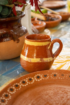 Traditional Mexican clay mug and decorated plate on dining table