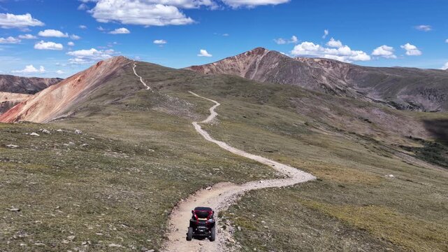 Aerial of side by side offroad vehicle on dirt road through Rocky mountain landscape in Colorado in high elevation tundra