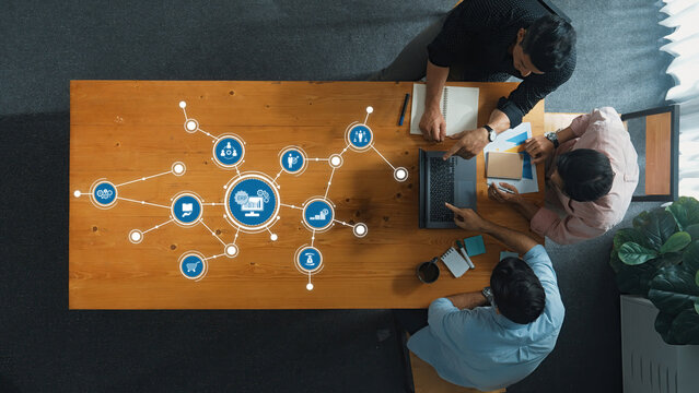 Top View of Business Professionals Collaborating on ERP Implementation with Digital Icons of Various Processes and Data Connections in Office Setting. Amity
