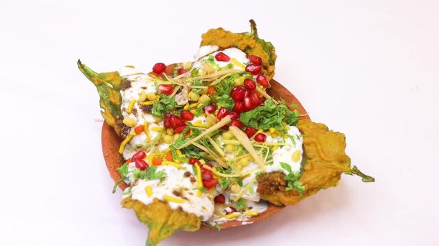 Palak ki chat being garnished with curd and served in a earthen plate