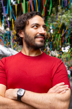 Confident young man with crossed arms on festive street