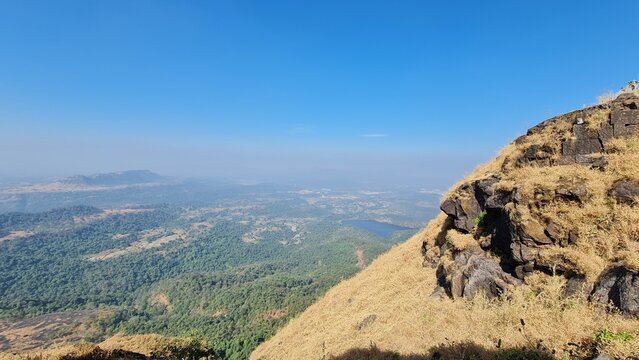 Scenic mountain valley and forest landscape viewed from a rocky hillside in Maharashtra India