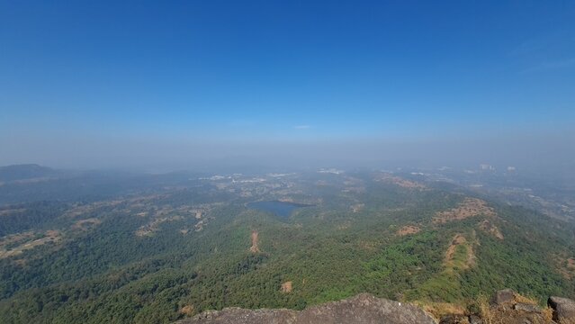 Panoramic view of forested Western Ghats landscape and reservoir from Manikgad Maharashtra India