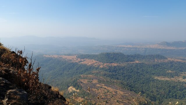 Hazy panoramic mountain landscape with forested hills and rocky plateaus in the Western Ghats India