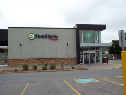 Gatineau, Quebec, Canada &ndash; June 26, 2026: The storefront of "Familiprix Extra" pharmacy features a modern building facade, entrance doors, and an asphalt parking lot under an overcast sky at 425 Bd la
