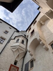 Low angle perspective looking up at the historic medieval stone walls and towers inside the inner courtyard of Hohensalzburg Fortress in Salzburg, Austria © Sergei