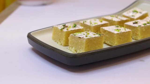 Milk barfi decorated with silver and dry fruits plated on white plate